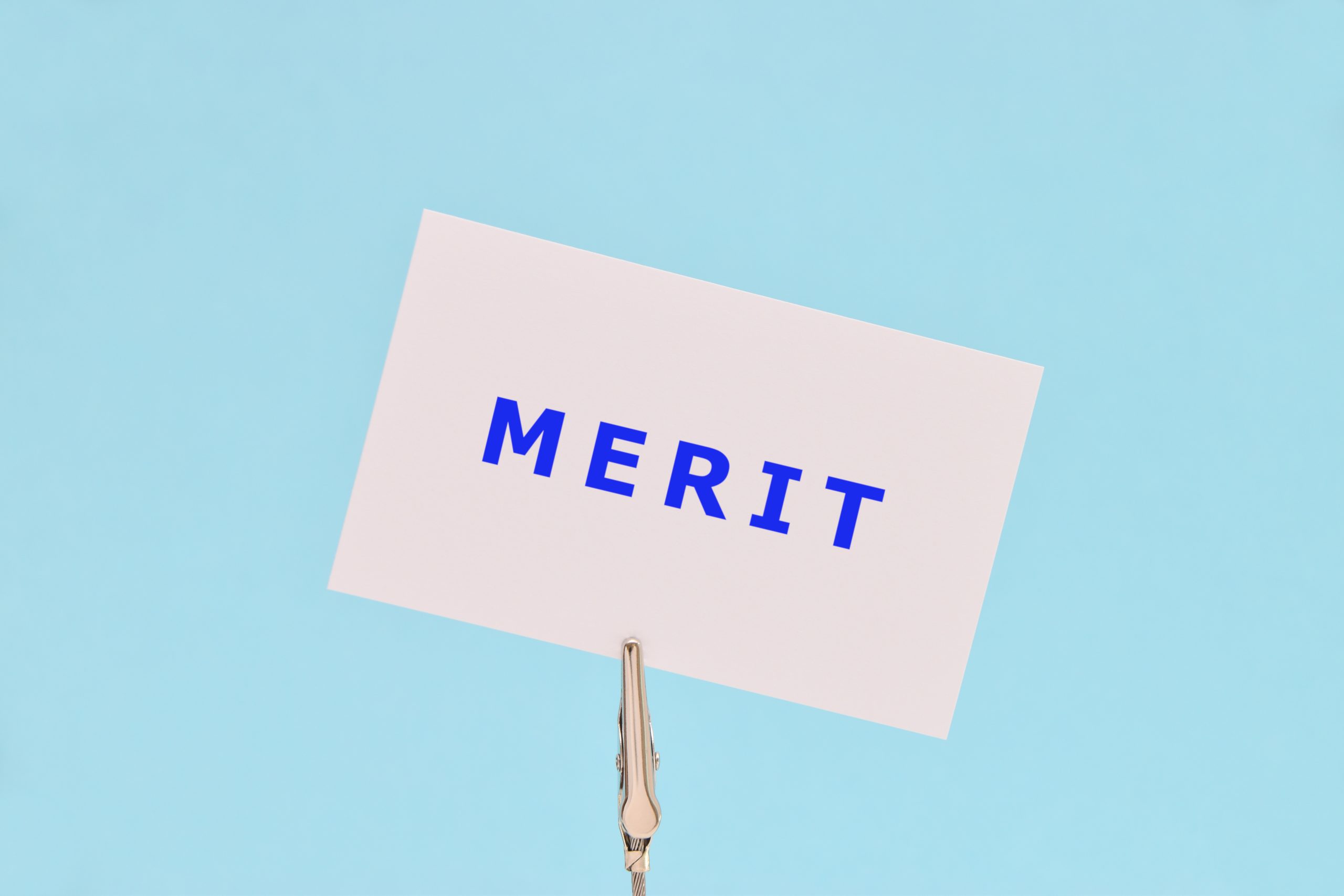 水色の背景に青い字でMERITと書かれた紙のイメージ
