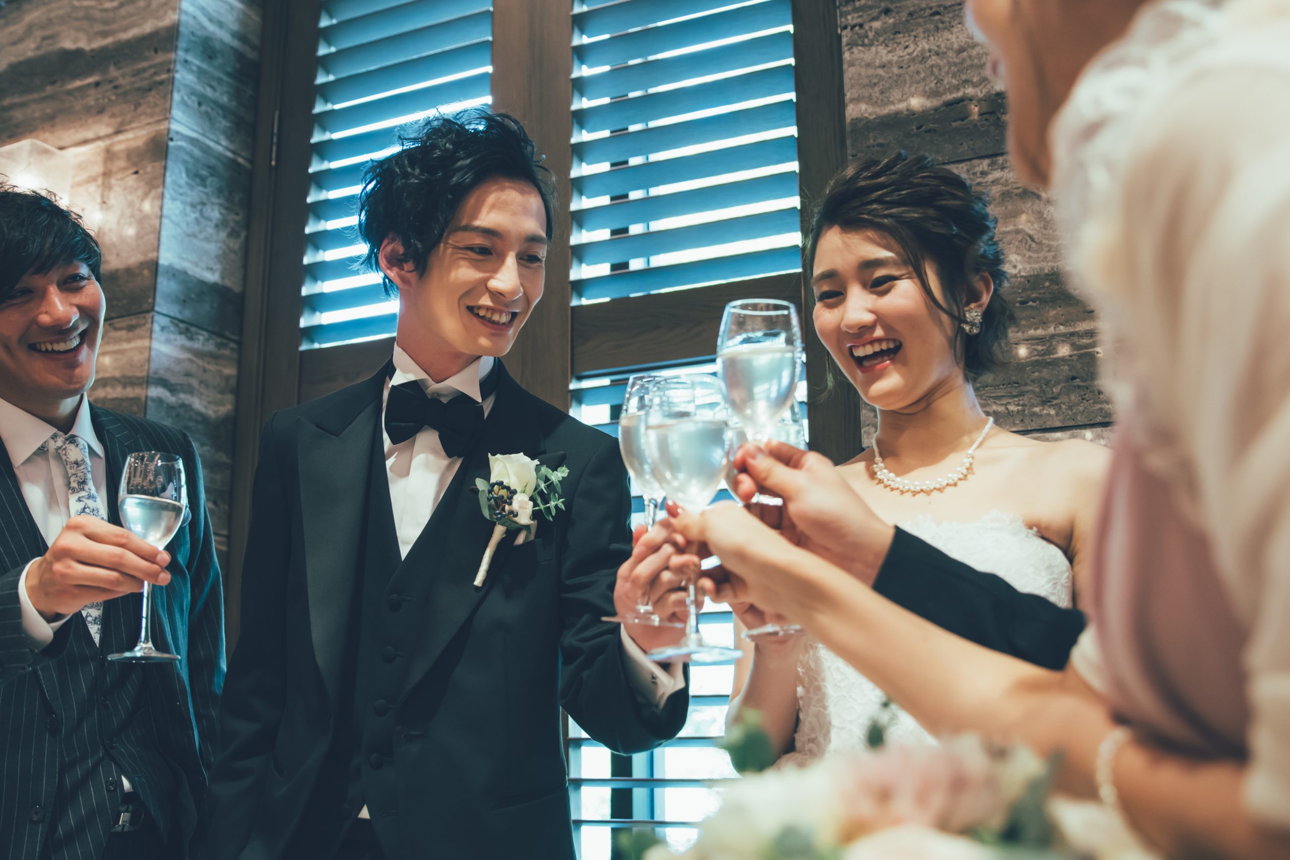 結婚式で新郎新婦がゲストと乾杯している写真