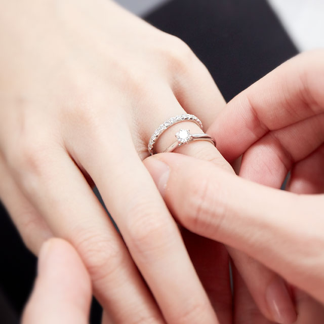 婚約指輪と結婚指輪を重ねづけしている写真