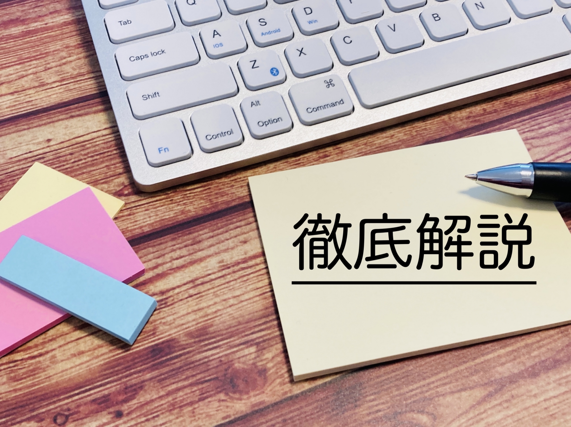 キーボードとカラフルな付箋と徹底解説と書かれた付箋とボールペンの写真