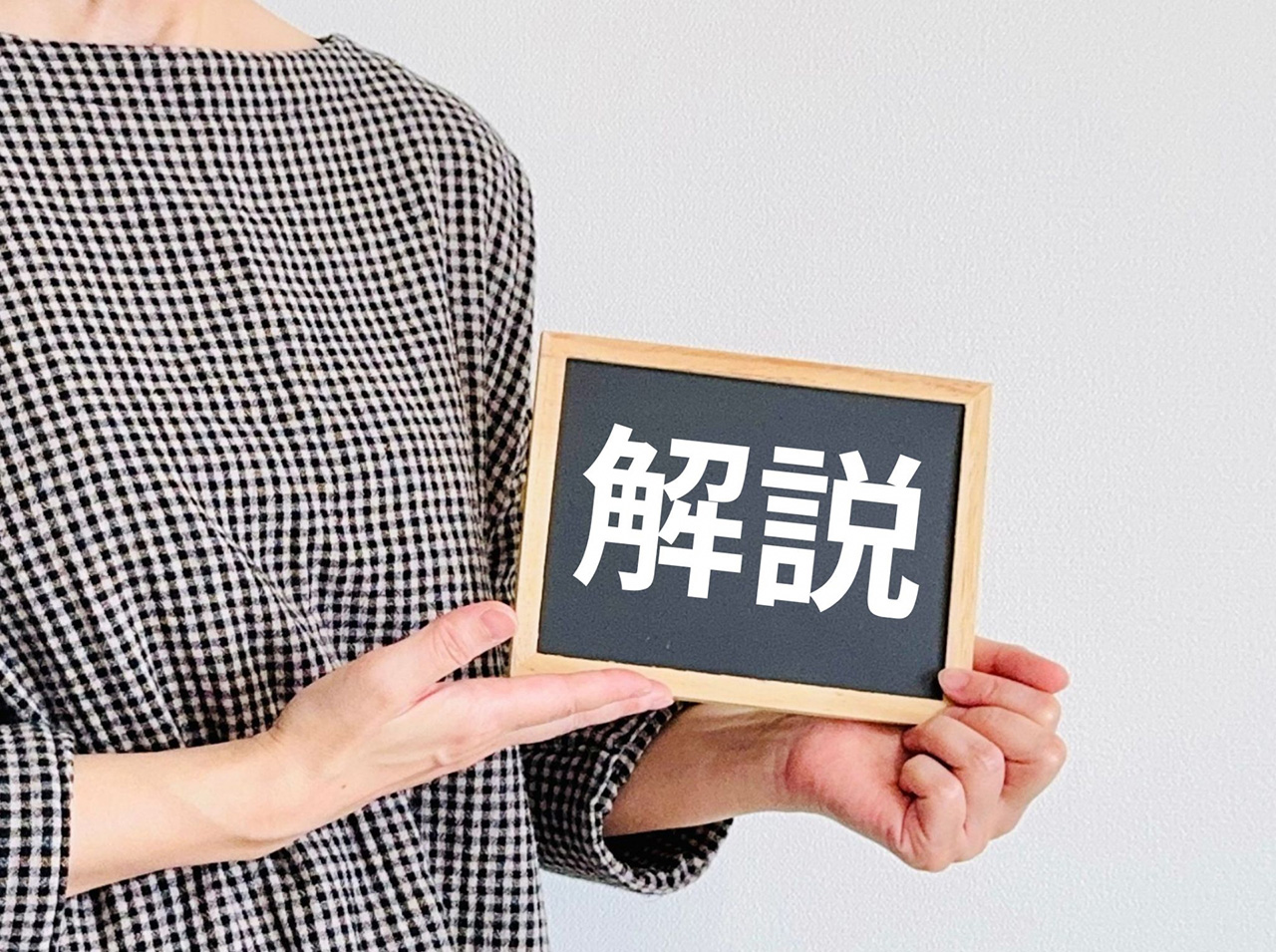 解説と書いてあるミニ黒板を持っている女性の写真
