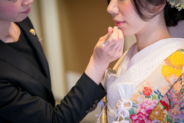 花嫁さんがお化粧をしてもらっている写真